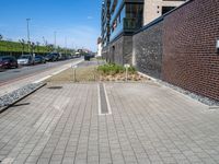 an empty parking lot sits in the middle of a city street and a large building next to it