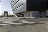 some people are walking across a crosswalk near a large building while two zebra crossing crosses are near