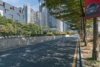 an empty street and a line of tall buildings are visible in this image, a man walks by