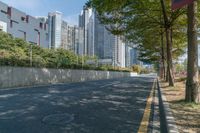 an empty street and a line of tall buildings are visible in this image, a man walks by