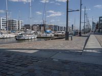 a brick path next to marina filled with lots of boats parked next to each other