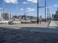 a brick path next to marina filled with lots of boats parked next to each other