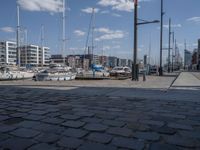 a brick path next to marina filled with lots of boats parked next to each other