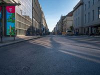 the sunlight reflects from several windows in a large building onto the street from outside the building