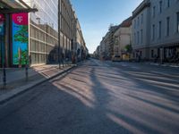 the sunlight reflects from several windows in a large building onto the street from outside the building