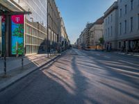 the sunlight reflects from several windows in a large building onto the street from outside the building