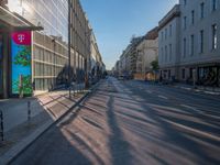 the sunlight reflects from several windows in a large building onto the street from outside the building