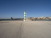 this is an ocean front with the town in the background and a road sign on the end of the walkway