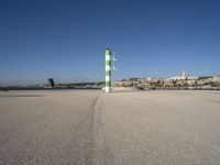 this is an ocean front with the town in the background and a road sign on the end of the walkway