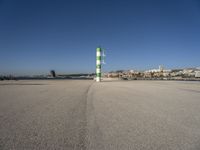 this is an ocean front with the town in the background and a road sign on the end of the walkway