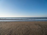 there is an image of an empty beach and ocean view area in the background on a sunny day