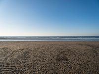 there is an image of an empty beach and ocean view area in the background on a sunny day