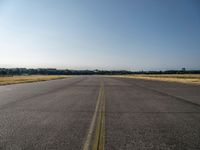 a street next to an airport on a sunny day and blue skies above the ground