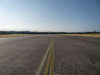 a street next to an airport on a sunny day and blue skies above the ground