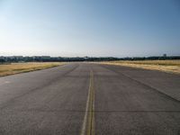 a street next to an airport on a sunny day and blue skies above the ground