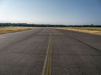 a street next to an airport on a sunny day and blue skies above the ground