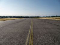 a street next to an airport on a sunny day and blue skies above the ground