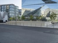 a empty street that is partially constructed by a modern building with curved glass windows in it