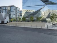 a empty street that is partially constructed by a modern building with curved glass windows in it