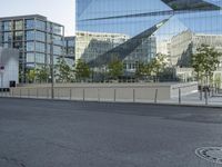 a empty street that is partially constructed by a modern building with curved glass windows in it