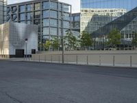 a empty street that is partially constructed by a modern building with curved glass windows in it