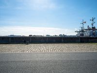 there are benches on the side of the road near the harbor area that contains docked ships