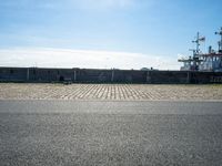 there are benches on the side of the road near the harbor area that contains docked ships