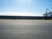 there are benches on the side of the road near the harbor area that contains docked ships