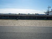 there are benches on the side of the road near the harbor area that contains docked ships