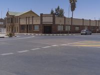 a building with the sign that reads to the right of the road is a closed street, with a yellow line on the road in front of it, and some buildings