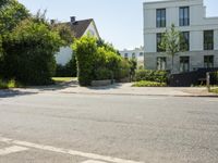 this is an image of a residential street corner with houses in the background and a street sign above