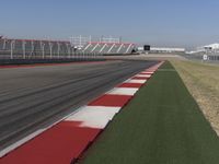 an empty track at a motorsports club with some red and white stripeing on it