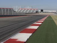 an empty track at a motorsports club with some red and white stripeing on it