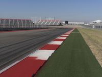 an empty track at a motorsports club with some red and white stripeing on it