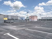 a parking lot with lots of parking space and buildings on both sides of it in the background