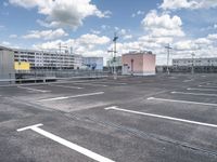 a parking lot with lots of parking space and buildings on both sides of it in the background