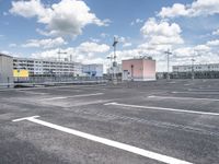 a parking lot with lots of parking space and buildings on both sides of it in the background