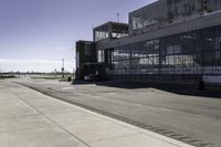 the sidewalk is empty during the day and empty around the corner of it, and the large building with two windows has been moved