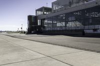 the sidewalk is empty during the day and empty around the corner of it, and the large building with two windows has been moved