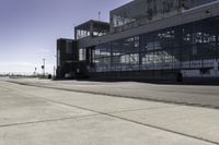 the sidewalk is empty during the day and empty around the corner of it, and the large building with two windows has been moved