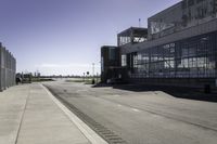 the sidewalk is empty during the day and empty around the corner of it, and the large building with two windows has been moved