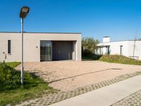 two very neat modern homes in an empty, peaceful setting, with paved walkways