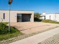 two very neat modern homes in an empty, peaceful setting, with paved walkways