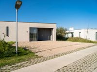 two very neat modern homes in an empty, peaceful setting, with paved walkways