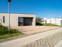 two very neat modern homes in an empty, peaceful setting, with paved walkways