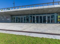 the exterior of a public building with a walkway in front of it on a sunny day