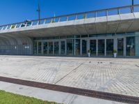 the exterior of a public building with a walkway in front of it on a sunny day