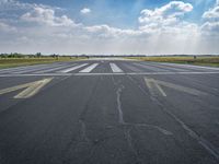 an empty runway with the sun shining brightly behind it to reveal a clear blue sky