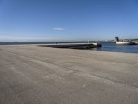 a parking space sitting on the side of a road next to the ocean with a boat coming up and a dock