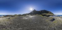 a 360 - view of a rocky shore on an island with the sun shining over it